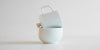 Side view of the Competition set in use. The base of the cup and the handle of the lid rest on either edge of the bowl, allowing the tea inside to be decanted hands-free.