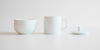 Side view of each piece of the competition brewing set. From left to right, the bowl, the brewing cup, and the lid.