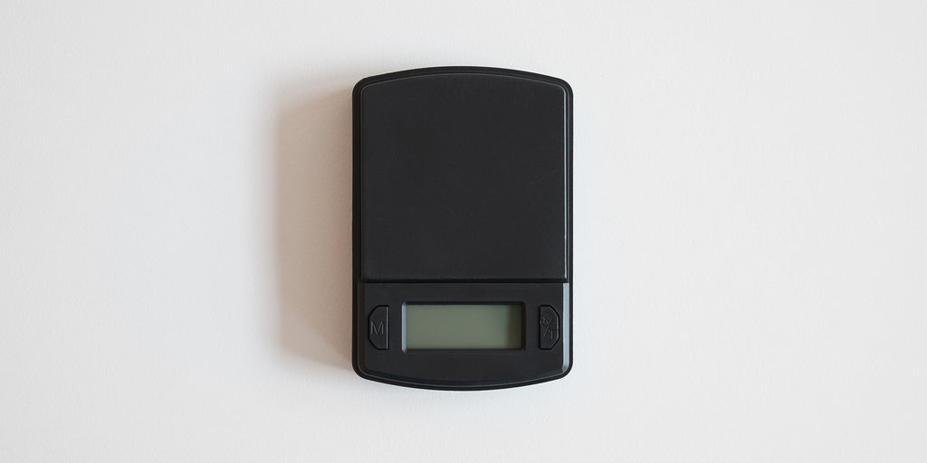 A matte black scale on a white background with the display turned off.