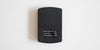 Bottom of a matte black scale. It has a sliding panel to insert batteries into, and four small feet on the corners.