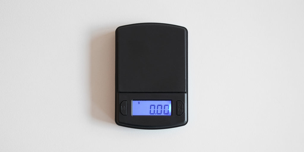 A matte black digital tea scale with a digital display showing 0.00 grams, placed on a white background.