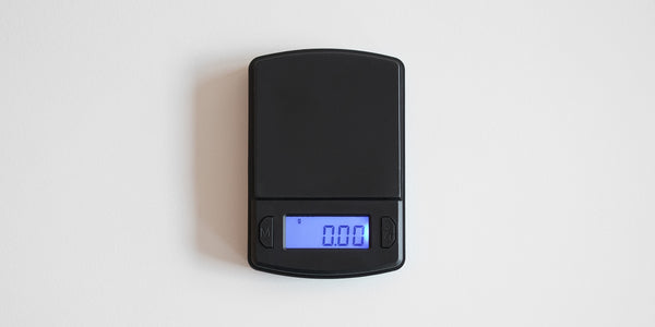 A matte black digital tea scale with a digital display showing 0.00 grams, placed on a white background.