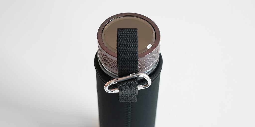 Top down view of the fully assembled thermos. A carabiner is attached to a strap coming off of the cozy.