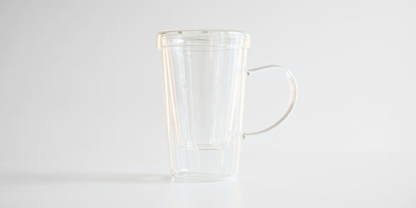 Side view of the glass infuser cup. The infuser is in the cup, and the lid covers it.