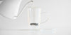 Side view of a glass cup with a glass infuser basket. The lid is off to the side, underneath the handle.