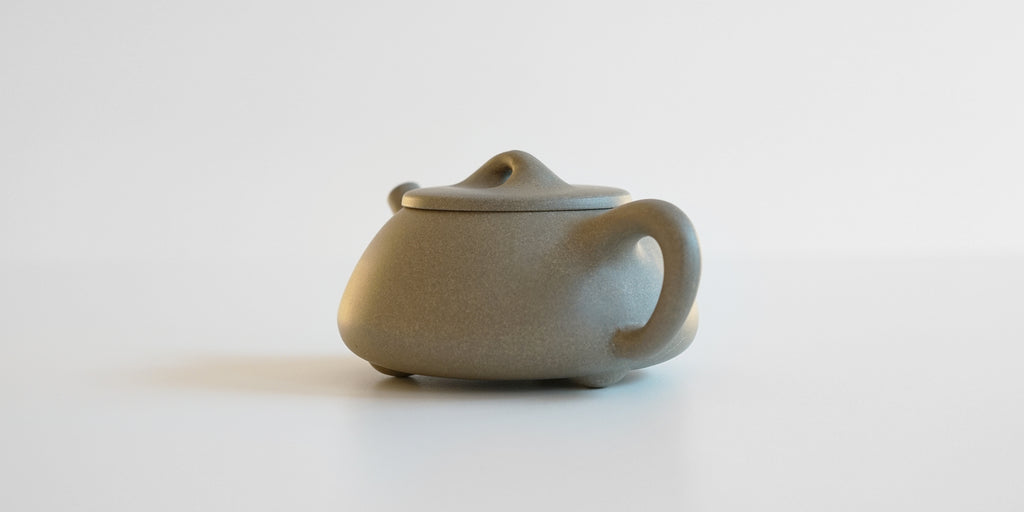 Rear view of a gray duanni yixing teapot, highlighting the handle.