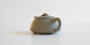 Rear view of a gray duanni yixing teapot, highlighting the handle.