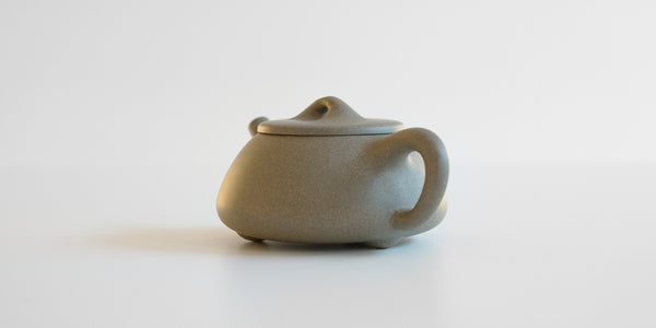 Rear view of a gray duanni yixing teapot, highlighting the handle.