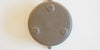 The base of a gray duanni yixing pot. It has three small feet around the outer edge, and a maker's mark stamped into the middle.
