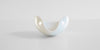 Front view of the pouring spout of a white ceramic tea dish.