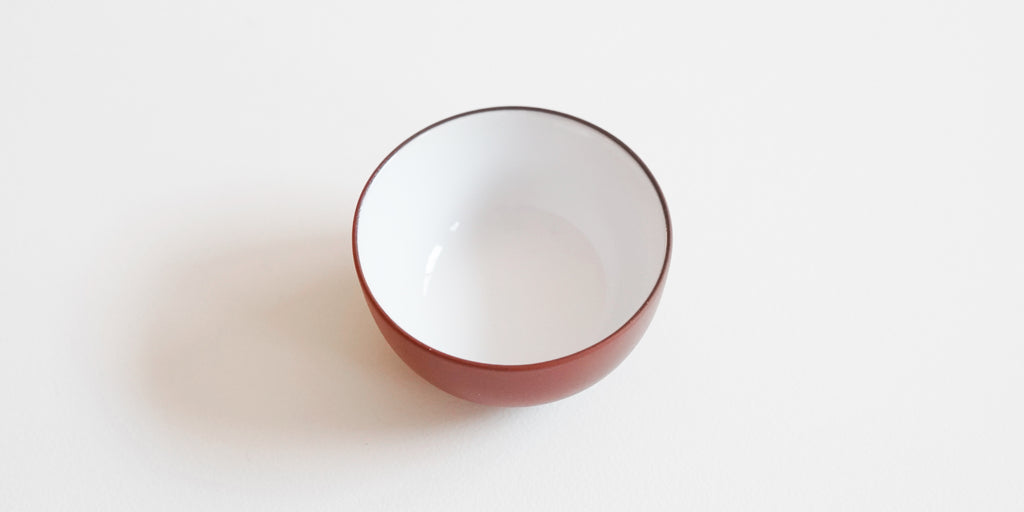 View of the inside of a teacup, the inside is white and the outside is terracotta-colored.