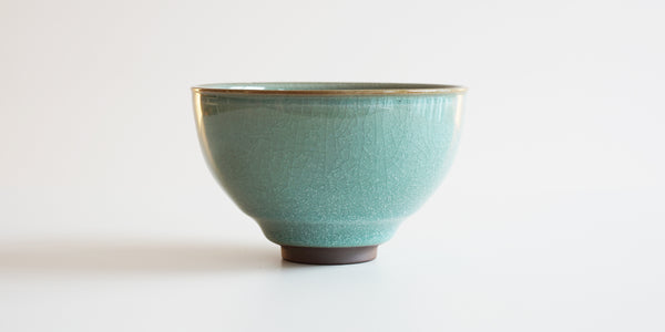 Side view of a Longquan style celadon bowl, showcasing the faint craquelure patterning and the slightly turned-out lip meant to conform to the user's mouth.