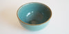 A top view of a Longquan-style celadon bowl, highlighting the faint craquelure patterns and light brown rim.