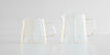 Two empty glass servers side by side. Smaller one on the left, larger on the right.