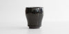 A side-view of a jian-ware cup, displaying the hare's fur texture on the otherwise black glaze.