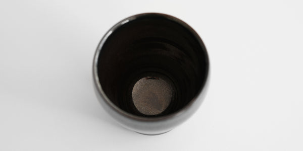 A top-down view of a jian-ware cup. Light shows the delicate hare's fur patterning on the inside.