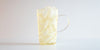 A glass cup filled with ice and jasmine tea on a white background.
