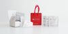 A party favor kit consisting of a red gift bag, a white mini gift box, and several tea sachets, and four samples of tea displayed on a white background.
