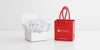 A white box displaying 4 samples of tea fanned out, and a small branded red bag.
