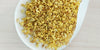 A white dish containing dry yellow osmanthus flowers.