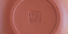 The bottom of a terracotta-colored yixing teapot. A maker’s mark is stamped into the base.