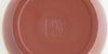 The bottom of a terracotta-colored yixing teapot. A maker’s mark is stamped into the base.