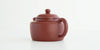 Rear view of a terracotta-colored yixing pot, highlighting the oval handle.