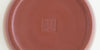 The bottom of a terracotta-colored yixing teapot. A maker’s mark is stamped into the base.