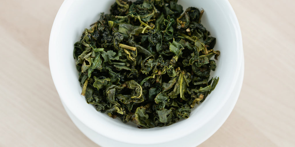 A top-down photo of brewed Formosa oolong tea leaves in a gaiwan.