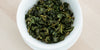 A top-down photo of brewed Formosa oolong tea leaves in a gaiwan.