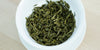 A top-down photo of brewed green tea leaves in a gaiwan.