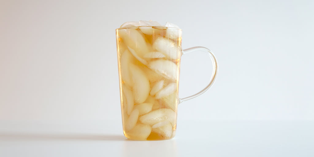 A glass cup filled with ice and Phoenix oolong tea on a white background.