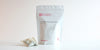 A large teabag filled with jasmine tea next to a package of Cold Brew Spring Jasmine