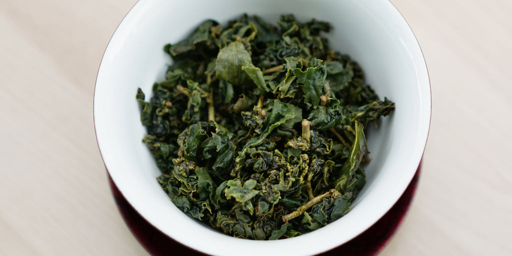 A top-down photo of brewed Formosa oolong tea leaves in a gaiwan.