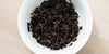 A top-down photo of brewed pu-erh tea leaves in a gaiwan.
