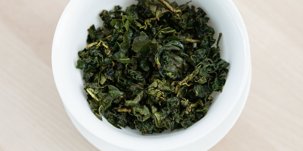A top-down photo of brewed Formosa oolong tea leaves in a gaiwan.
