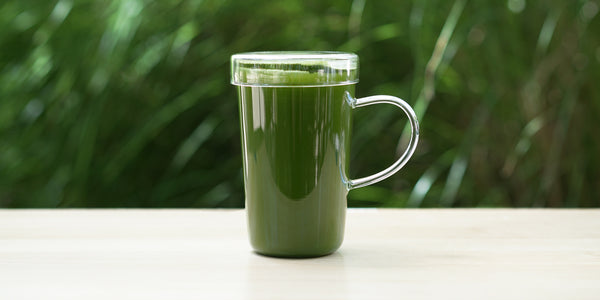A glass cup full of brewed matcha