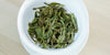 A top-down photo of brewed green tea leaves in a gaiwan.