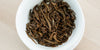 A top-down photo of brewed black tea leaves in a gaiwan.