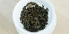 A top-down photo of brewed green tea leaves in a gaiwan.