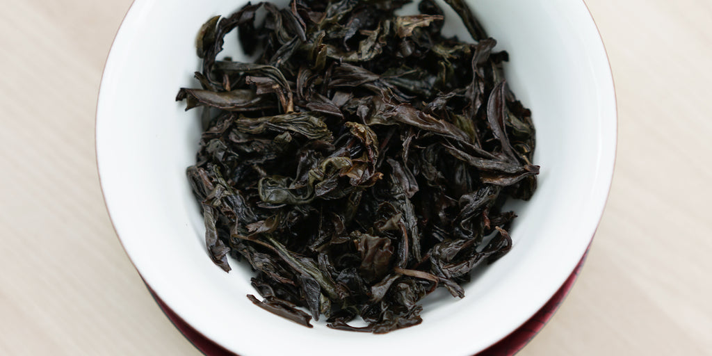 A top-down photo of brewed Wuyi oolong tea leaves in a gaiwan.