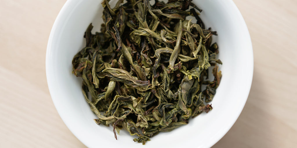 A top-down photo of brewed pu-erh tea leaves in a gaiwan.