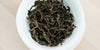 A top-down photo of brewed Phoenix oolong tea leaves in a gaiwan.