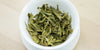 A top-down photo of brewed green tea leaves in a gaiwan.