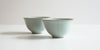 Side view of a pair of blue-green celadon teacup, designed to look like a lotus flower.