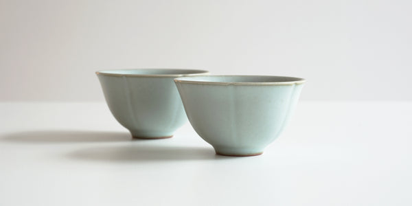 Side view of a pair of blue-green celadon teacup, designed to look like a lotus flower.