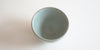 Top down view of a blue-green celadon teacup, with a grayish rim.