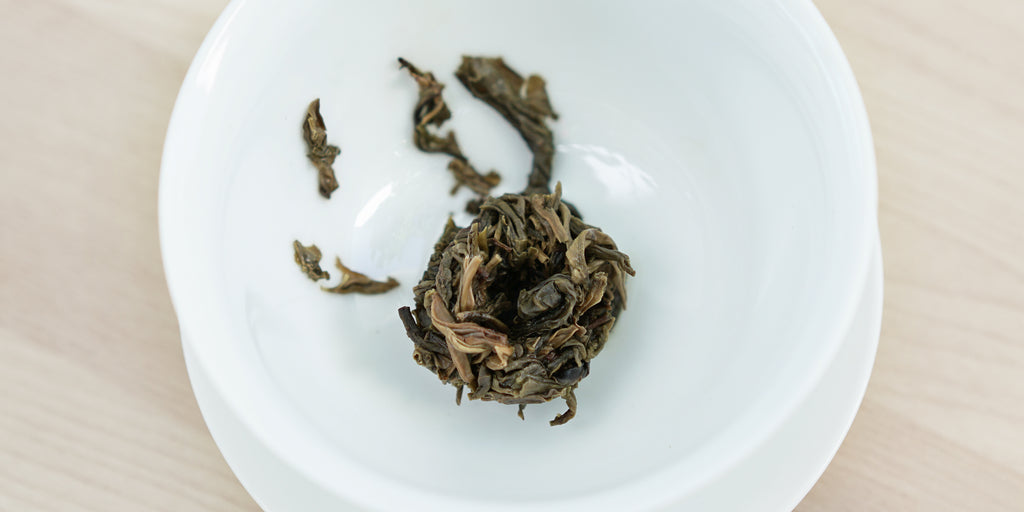 A top-down photo of brewed pu-erh tea leaves in a gaiwan.