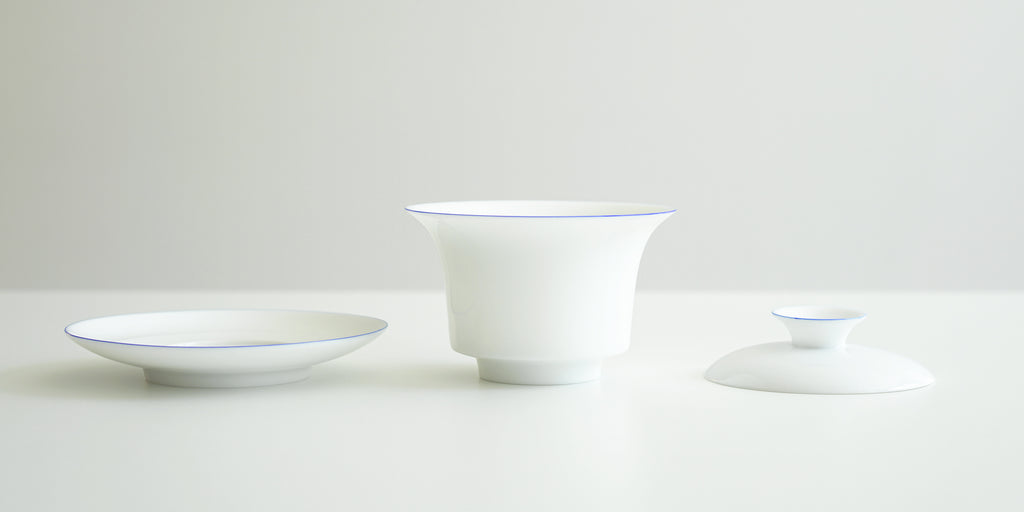 Side view of all the pieces for the gaiwan. From left to right, the plate, the bowl, and the lid