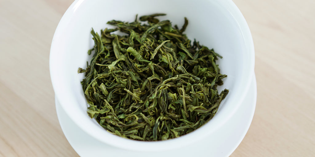 A top-down photo of brewed green tea leaves in a gaiwan.